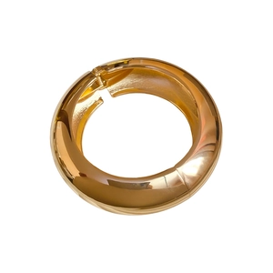 Polished gold mirror finish metal bangle with a side hinge closure on a white background