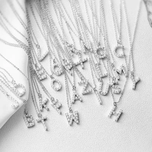 Detailed view of elegant silver necklaces featuring pearl-studded A-Z letter pendants