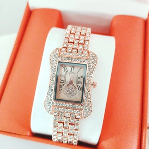 Elegant rose gold square watch with rhinestones and Roman numerals on an orange gift box