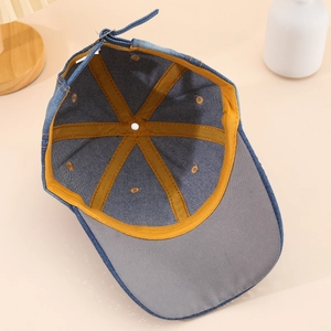 Détail de l'intérieur de la casquette en jean avec coutures renforcées et boucle en métal