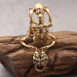 Detail of movable golden metal skeleton pendant with articulated joints on wood