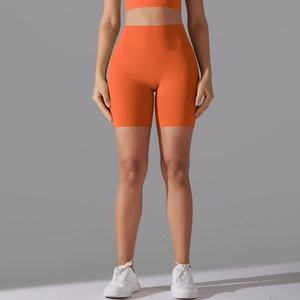 Detailed view of orange high-waist fitness yoga shorts with seamless elastic fabric