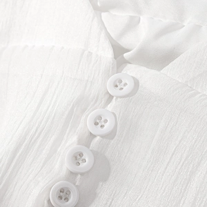 Close-up of white vertical pleated fabric texture with elegant four-hole buttons