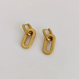 Detailed view of gold square chain link earrings with horizontal ribbed metal texture
