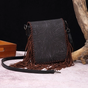 Bohemian black leather crossbody bag with vintage floral embossing and long brown fringe