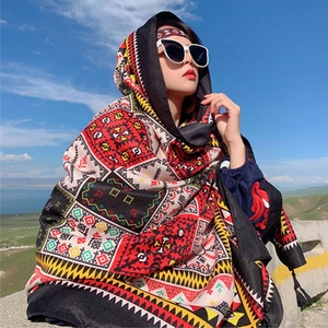 Detailed close-up of a red and black ethnic pattern linen shawl against a blue sky