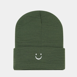 Close-up of olive green ribbed beanie featuring white minimalist smiley face embroidery