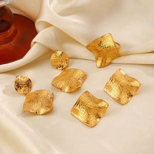 Golden irregular square jewelry set with hammered texture earrings and ring on silk