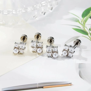 Vintage geometric silver earrings set with sparkling zircon and pearls on white background