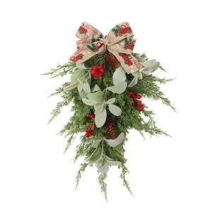 American farmhouse Christmas hanging swag with pinecones, red berries, and festive burlap bow