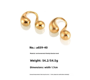 Macro detail of U-shaped gold earrings in polished and textured titanium steel finishes