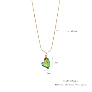 Détail du collier en acier inoxydable doré avec un pendentif cœur en verre vert