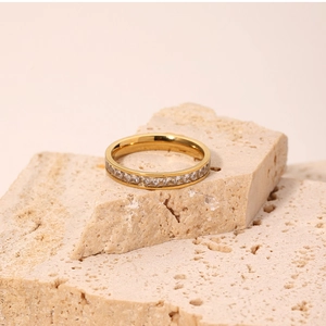 Detailed close-up of gold titanium steel ring with sparkling crystals on stone