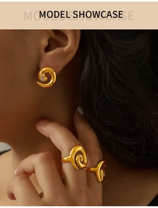 Close-up of model wearing golden spiral jewelry set with earrings and rings
