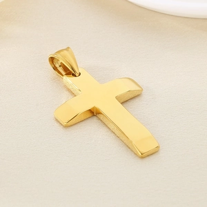 Macro close-up of a polished gold cross pendant showing smooth metallic texture