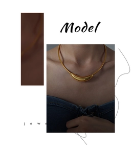 Detail of minimalist gold plated curved moon pendant on a sleek snake chain necklace