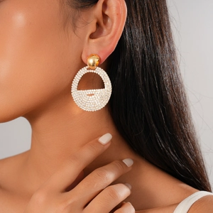 Close-up of elegant gold geometric hoop earrings with diamonds worn by a model