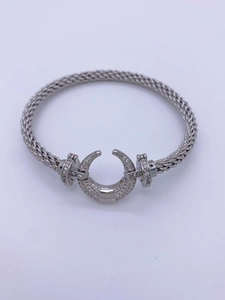 Macro shot of silver woven couple bracelet with zircon-encrusted crescent charm