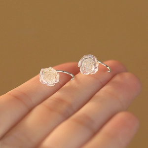 Iridescent rose flower earrings in S999 sterling silver held on fingertips