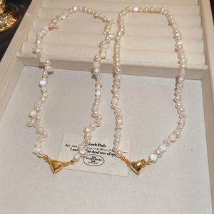 Baroque freshwater pearl necklace with 18K gold heart-shaped magnetic clasp on tray