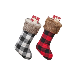 Large red and black buffalo plaid Christmas stockings with faux fur cuffs and gift boxes