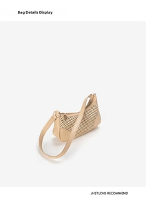 Close-up of woven straw underarm bag with smooth leather piping and metal zipper detail