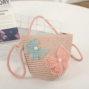 Detail of child straw crossbody bag with delicate butterfly appliques and pearl accents