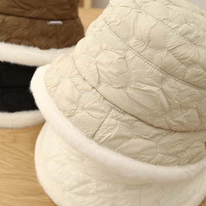 Close-up of winter quilted bucket hat showing fuzzy faux fur trim and geometric stitching