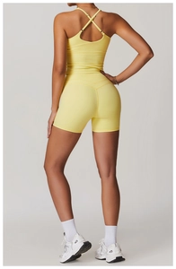 Détail du haut de sport jaune à dos croisé et short de yoga taille haute sur modèle