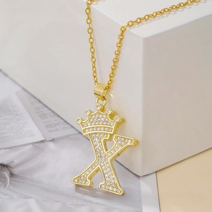 Detail of gold letter X pendant with sparkling crown design and cubic zirconia