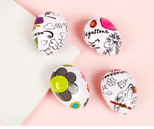 Detail view of four white egg-shaped hairbrushes with cute cartoon patterns and typography