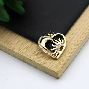 Macro view of 18K gold plated heart pendant with pavé set zircon sun and moon motifs