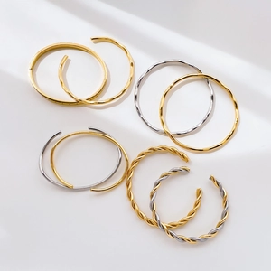 Minimalist gold and silver curved bangles with twisted texture and polished finish