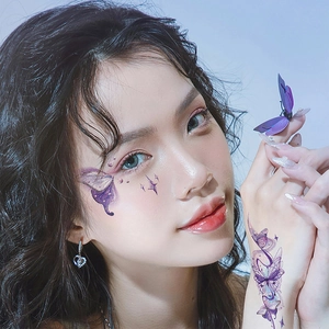 Detailed view of purple butterfly tattoo stickers on model face and hand skin