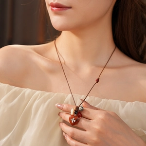 Detailed view of bohemian wax cord necklace with heart pendant and multi-texture beads
