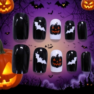 Halloween press-on nails featuring black and white bats and pumpkins on a glossy finish