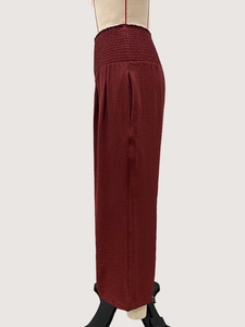 Détail du pantalon taille haute rouge vin avec taille élastique à plis texturés