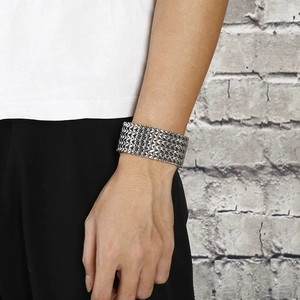 Men's silver woven mesh stainless steel bracelet with buckle on model with brick wall