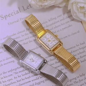Elegant gold and silver square quartz watches with elastic bands on a floral background