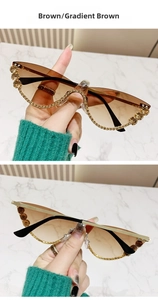 Close-up of cat-eye sunglasses with gold rhinestones and brown gradient lenses