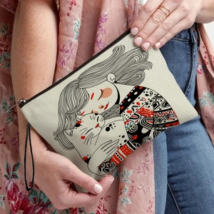 Minimalist cat print makeup bag with zipper and wristlet strap shown in lifestyle use