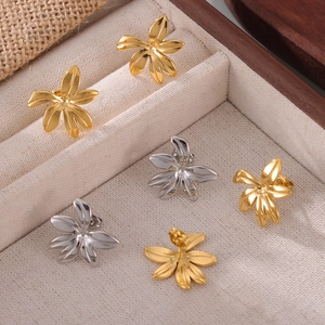 Minimalist flower-shaped gold and silver titanium steel earrings in a jewelry box