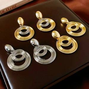 Detailed view of layered geometric hoop earrings in gold, silver, and mixed metallic finishes