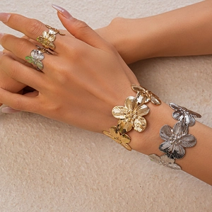 Detail of metal flower bracelet with radiant petal texture and golden finish