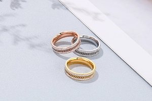 Detail of three-tone stackable rings with double-row crystals and chain-link texture