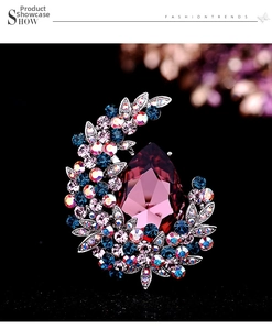 Detailed view of teardrop purple crystal and colorful flower cluster brooch