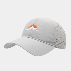 Détail de casquette grise avec trous de ventilation laser et broderie de montagne