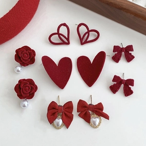 Five pairs of red flocked tulip and bow earrings with elegant pearl and metal accents