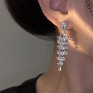 Silver drop tassel earrings with cubic zirconia stones worn by a model in a close-up shot