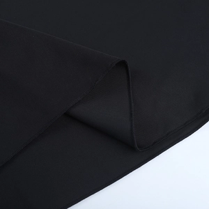 Primer plano del tejido negro del vestido mostrando la textura de punto y la costura